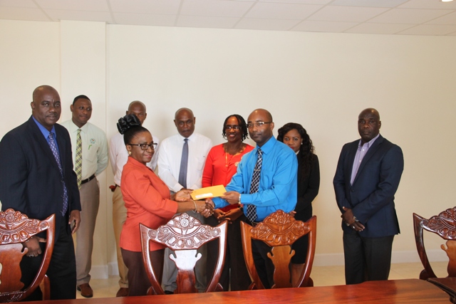 Director of Social Security Sephlin Lawrence, on behalf of the St. Christopher and Nevis Social Security Board, hands over $10M cheque to Dexter Boncamper, General Manager of the Nevis Housing and Land Development Corporation, at a brief ceremony at the Social Security conference room at Pinney’s Estate on January 24, 2017. Looking on are (l-r) Chairman of the St. Christopher and Nevis Social Security Board of Directors Oscar Walters, Secretary to the Board Leon Charles, Deputy Director Steve Wrenford, Assistant Director of the Social Security Nevis Branch Vernel Powell, Board Member Jacqueline Brookes-Jeffers, Legal Counsel in the NIA Rhonda Nisbett-Browne and Hon. Alexis Jeffers, Minister responsible for Housing and Lands on Nevis and Chairman of the Nevis Housing and Land Development Corporation Board of Directors